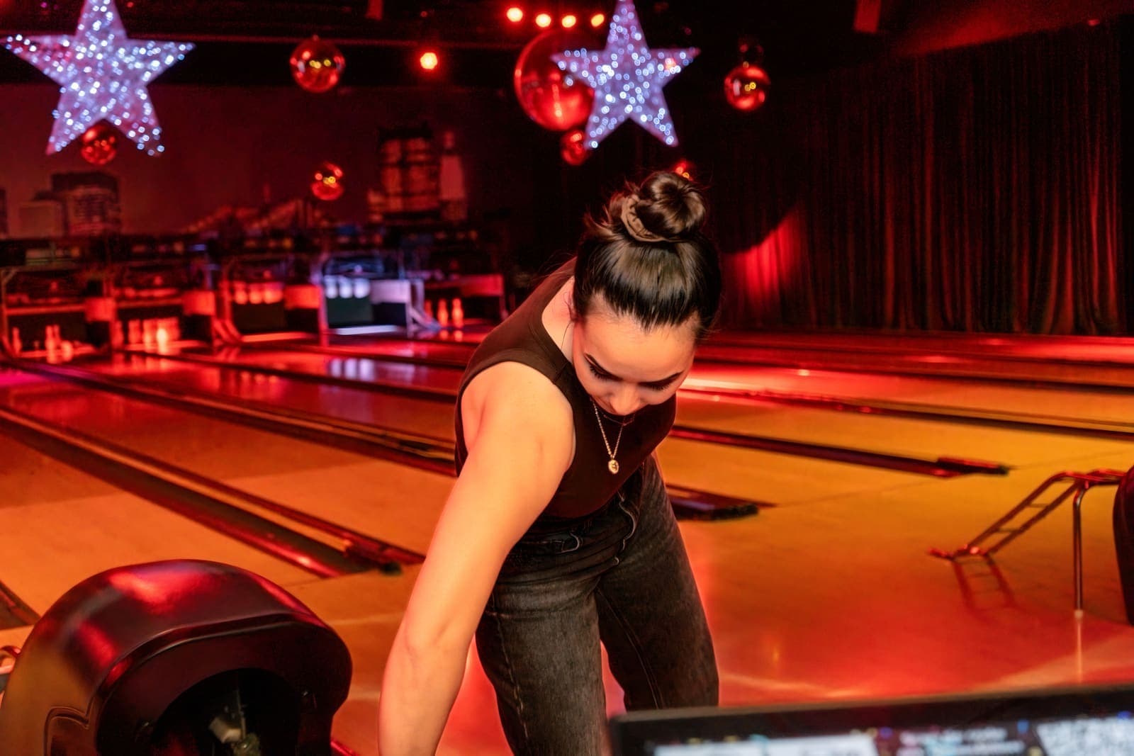 Een gast pakt een bal uit de ballenretour onder rood licht en lichtsterren
