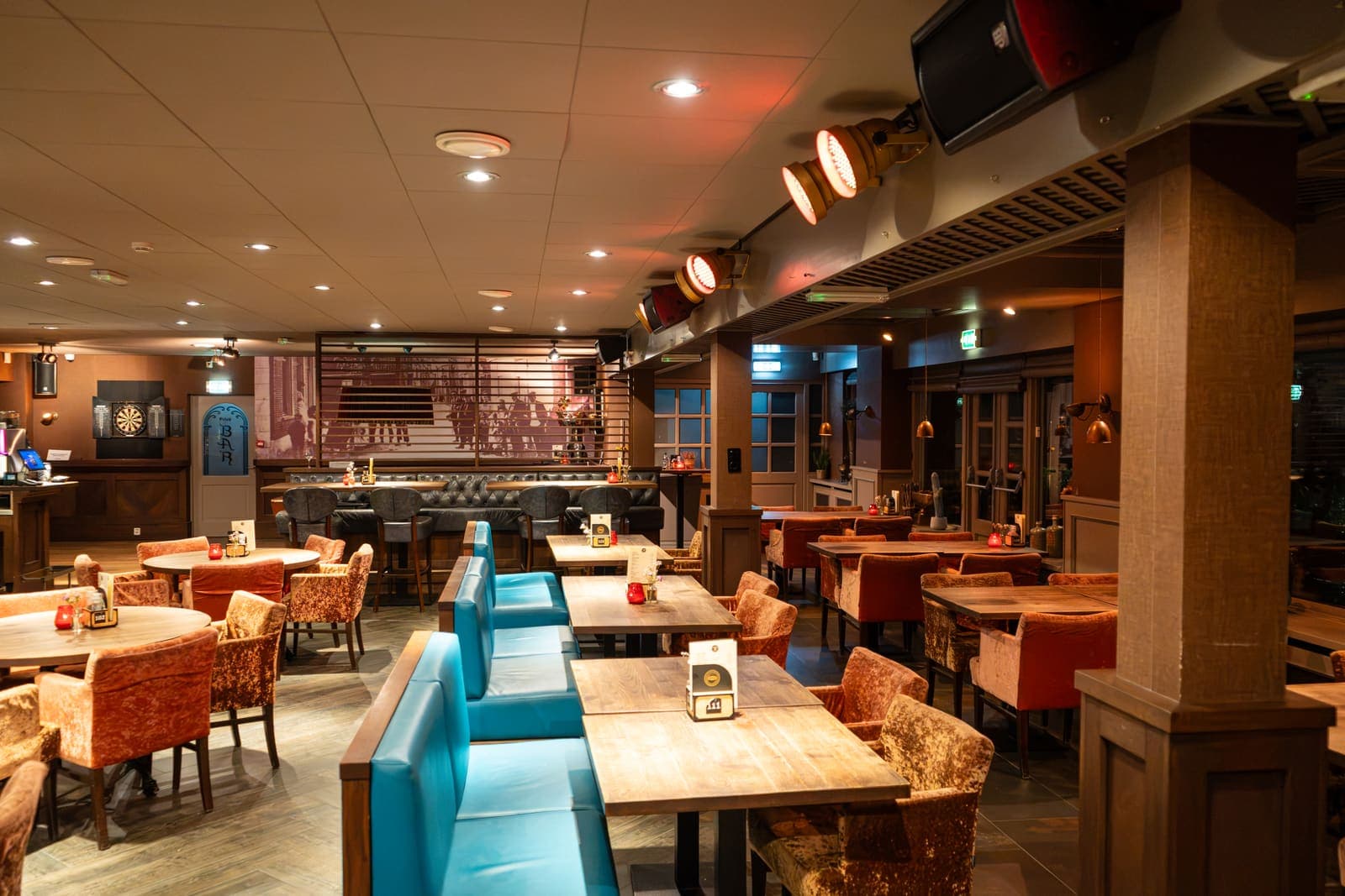 Turquoise banken en houten tafels in het Grand Café