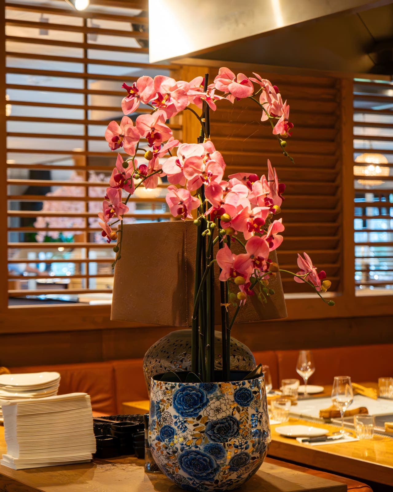 Een roze orchidee tussen de tafels van het restaurant