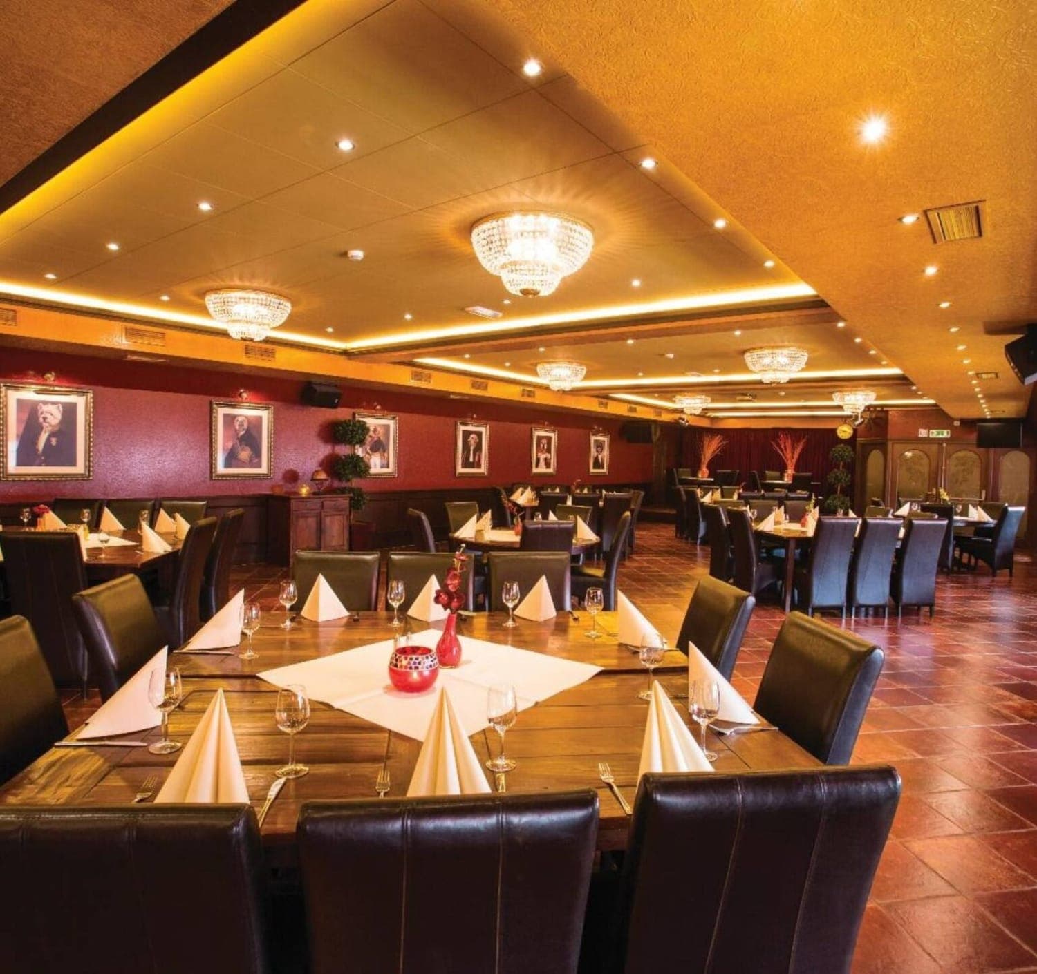 Een rustig gedekte zaal met witte tafelkleden en gedempt licht