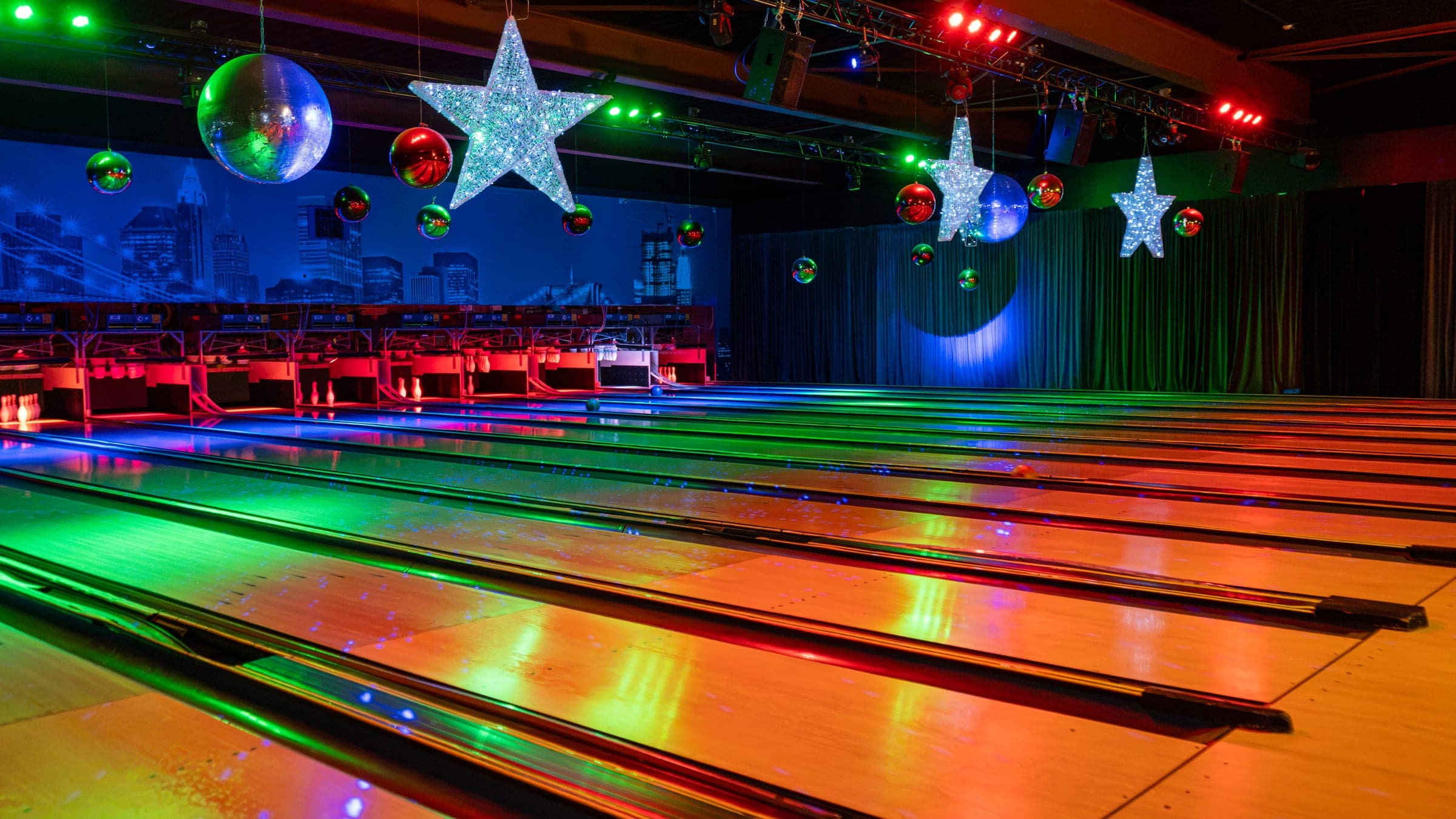 De twaalf bowlingbanen van Bobs in Uitgeest in gekleurd licht, met discobollen en lichtsterren boven de banen