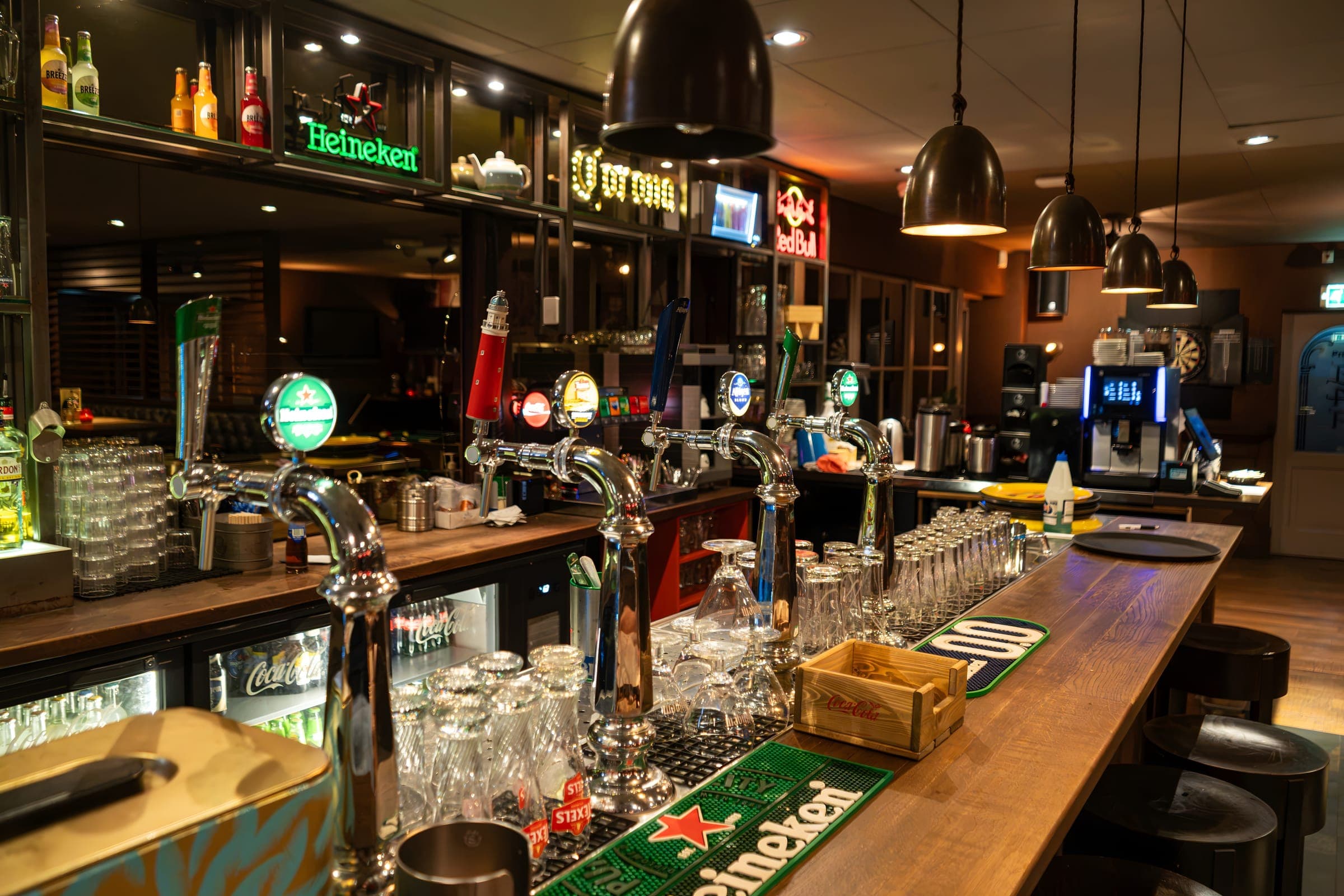 De biertaps op de bar van het Grand Café, met de glazen erachter klaargezet