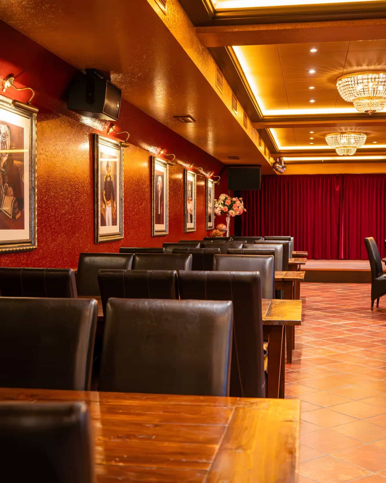 Tafels in de Grand Salle met het podium en het rode gordijn erachter