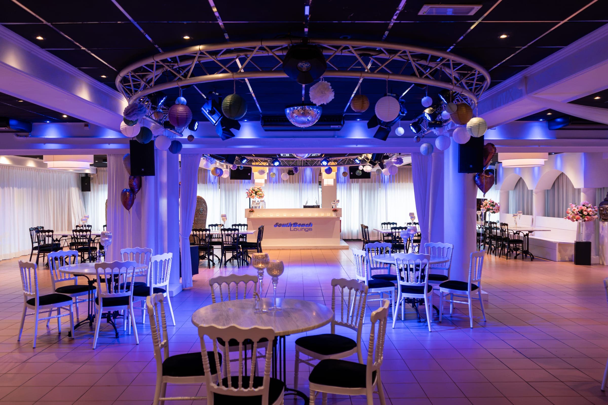 De ronde truss met lampionnen en een discobol boven de dansvloer van de South Beach Lounge