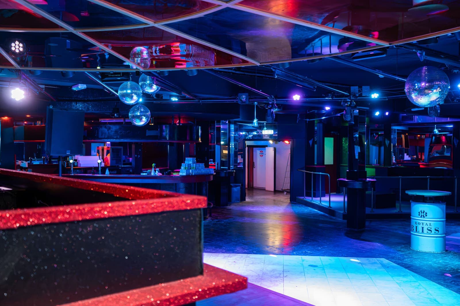 Discobollen boven de dansvloer en de bar van de club, in blauw licht