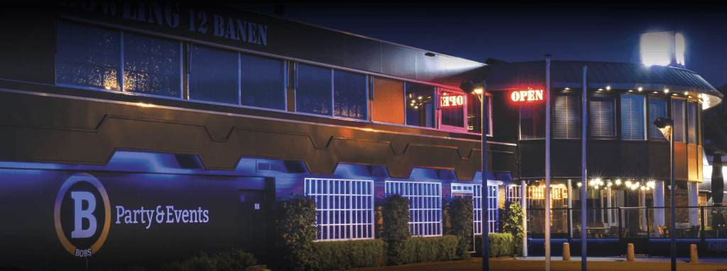 De verlichte gevel van Bobs in het donker, met BOWLING 12 BANEN boven de ramen